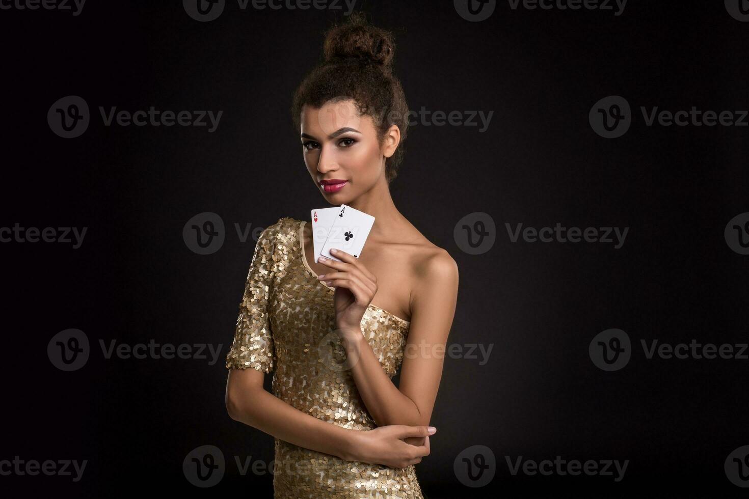 mujer victorioso - joven mujer en un de buen tono oro vestir participación dos ases, un póker de ases tarjeta combinación. foto