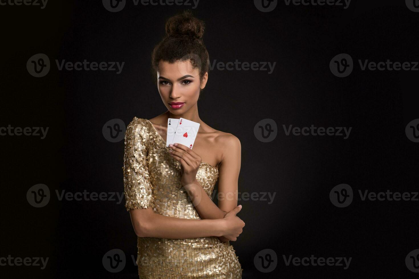 mujer victorioso - joven mujer en un de buen tono oro vestir participación dos ases, un póker de ases tarjeta combinación. foto