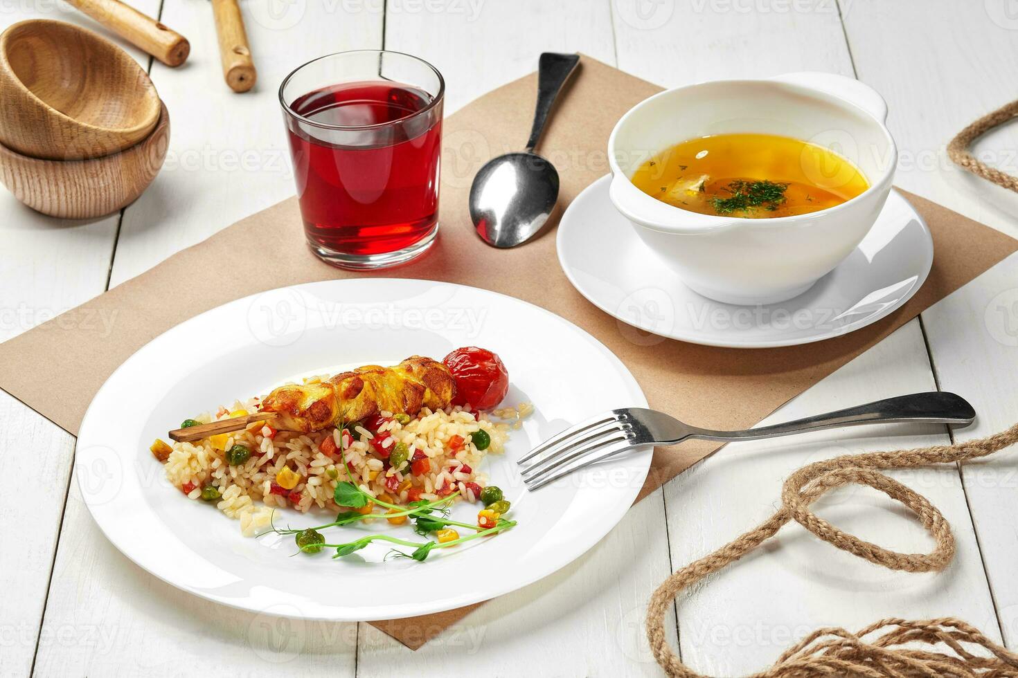 Kids set lunch of meat broth, rice with vegetables and chicken skewer, berry drink photo