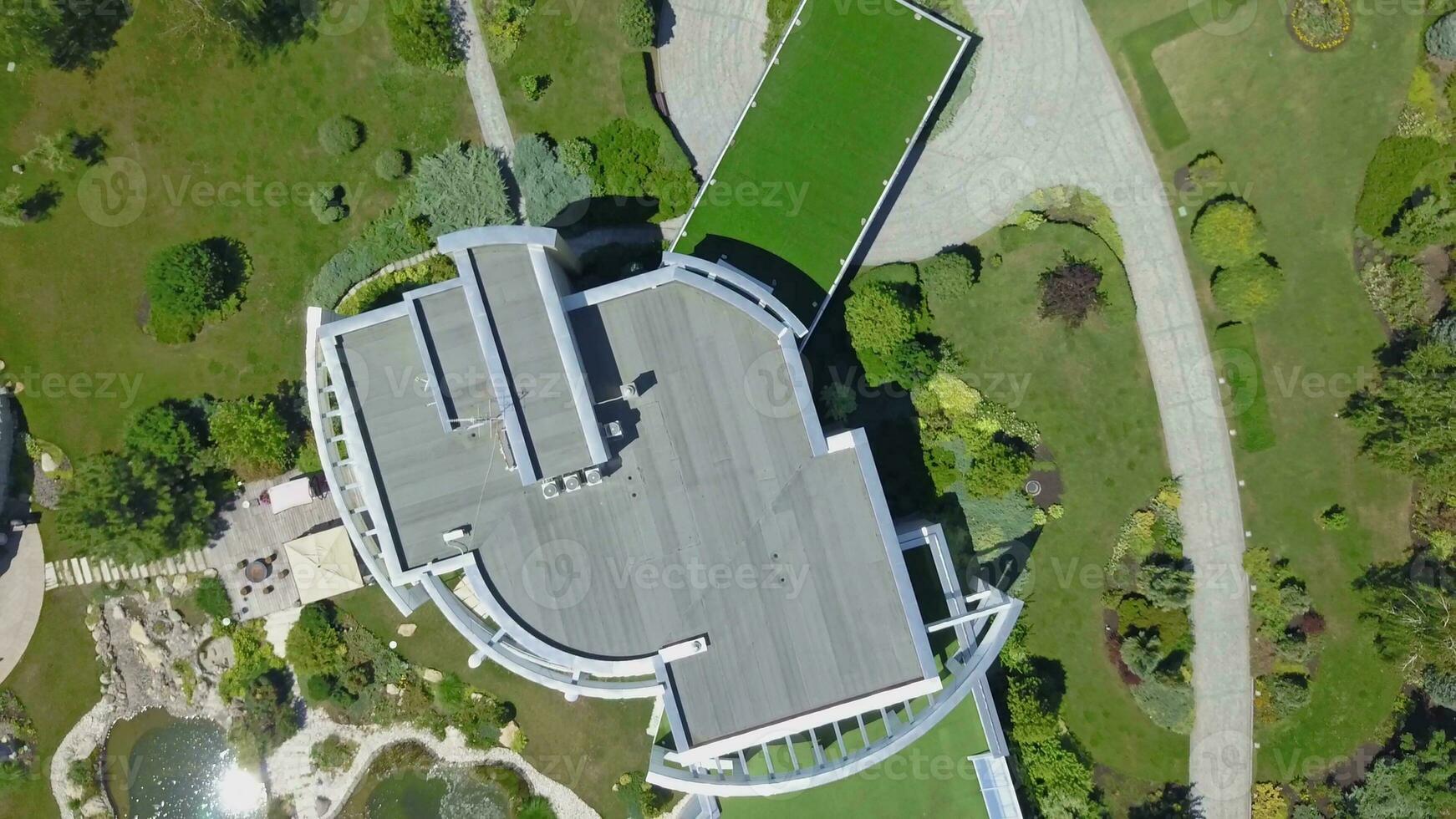Top view of country mansion surrounded by garden with green lawns and pond in summer photo