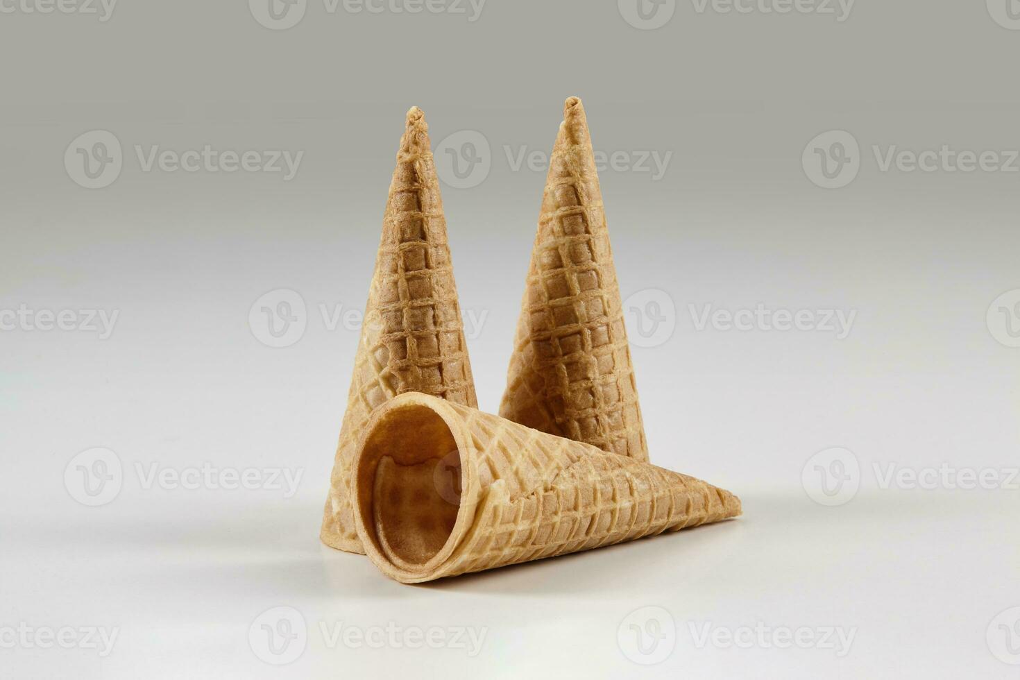 Three empty, tasty wafer cones for ice cream isolated on white. Concept of food, treats. Mockup, template for your advertising and design. Close up photo