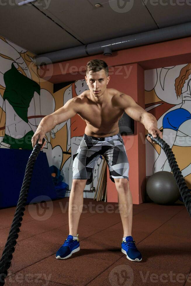 joven hombre trabajando fuera con batalla cuerdas a crossfit gimnasio  35419577 Foto de stock en Vecteezy