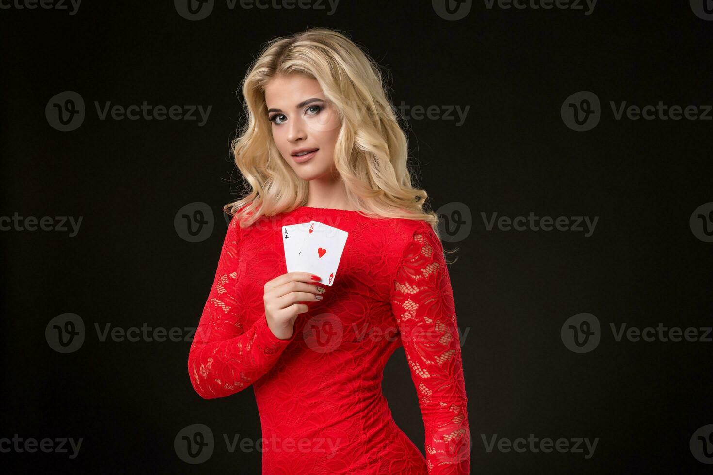 Young beautiful blond woman with playing cards over black. Poker photo