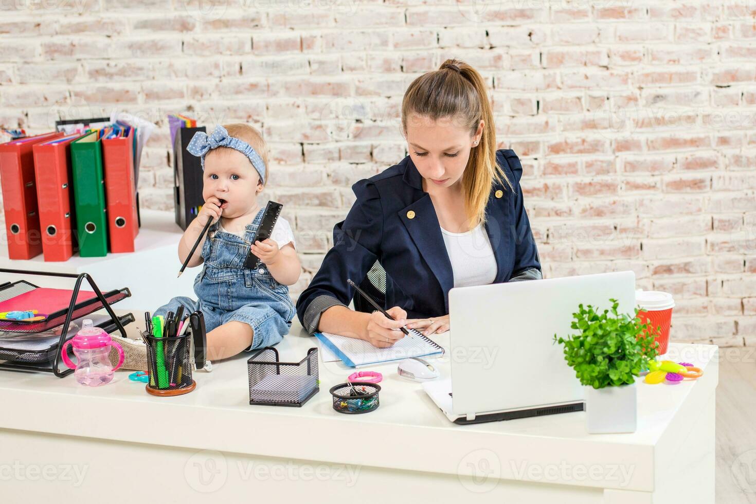 Businesswoman mother woman with a daughter working at the laptop photo