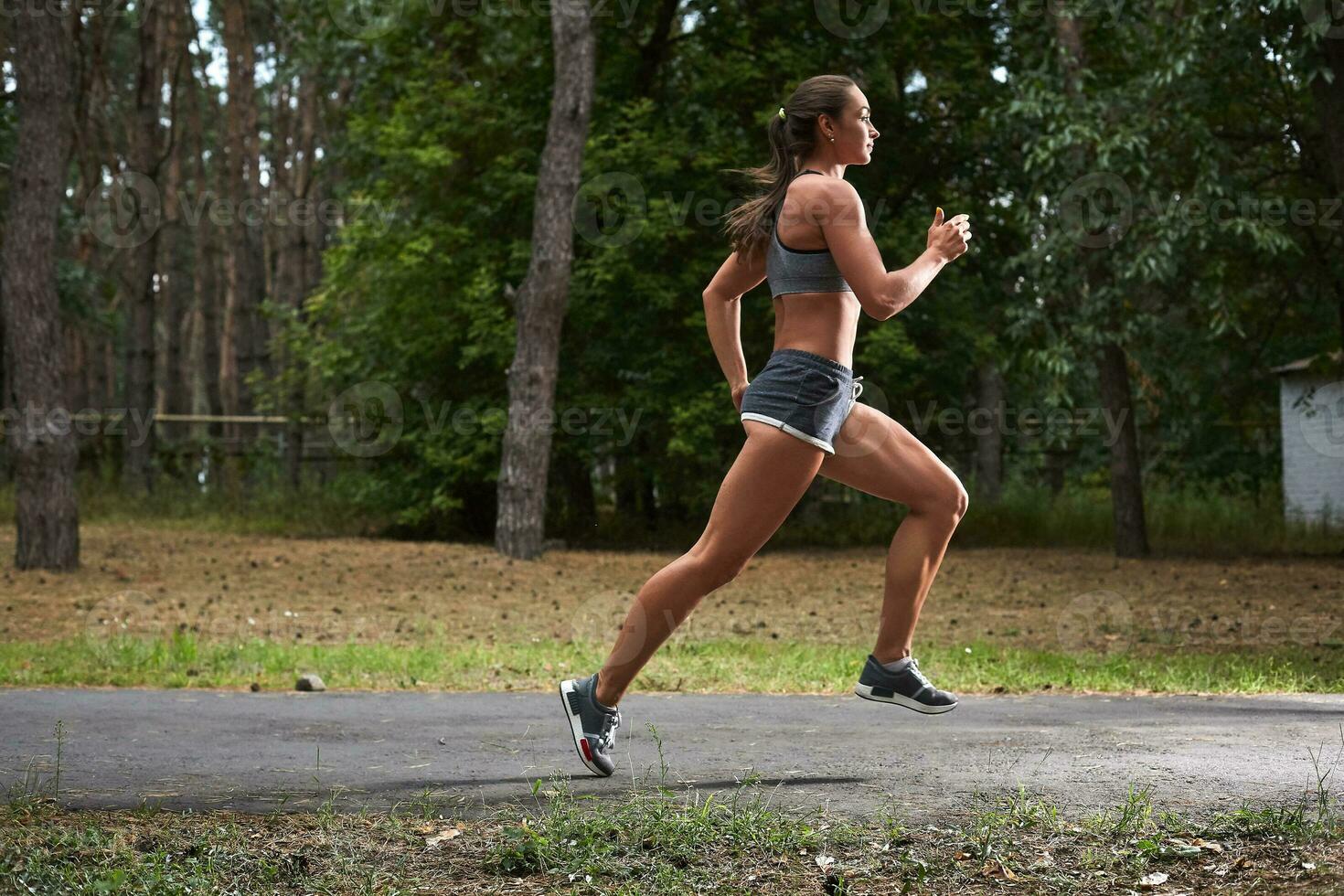 Young woman running outdoors in a city park photo