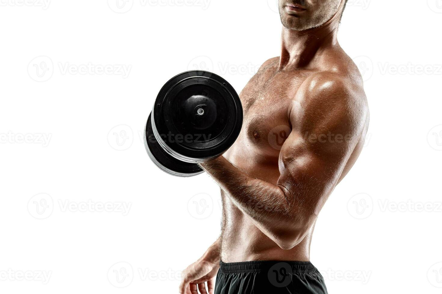 Handsome muscular man with bare chest lifting dumbbell, studio shot on white background photo