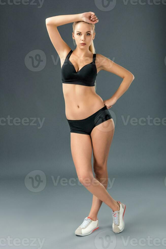 Young beautiful woman in fitness wear trained female body photo