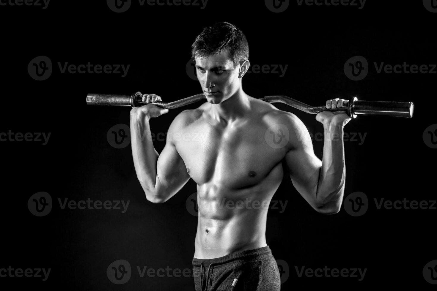 Strong man holding barbell on his shoulders, photo