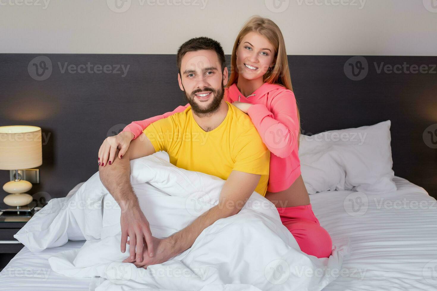 Young lovely couple have fun in a bed photo