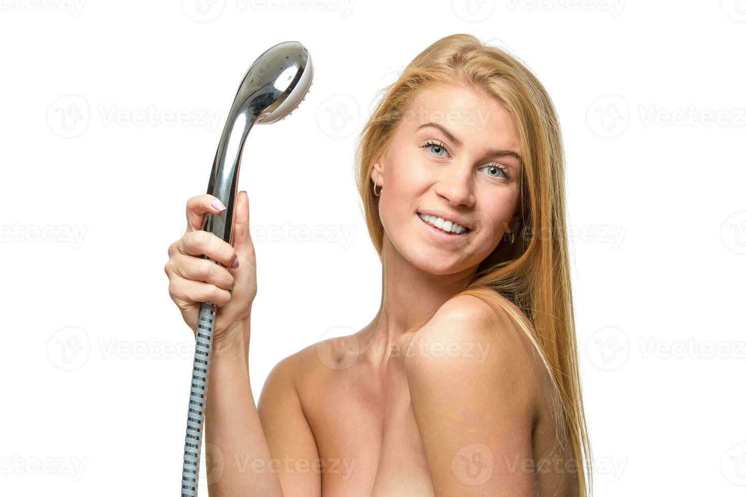 Young woman in a towel holding shower head photo