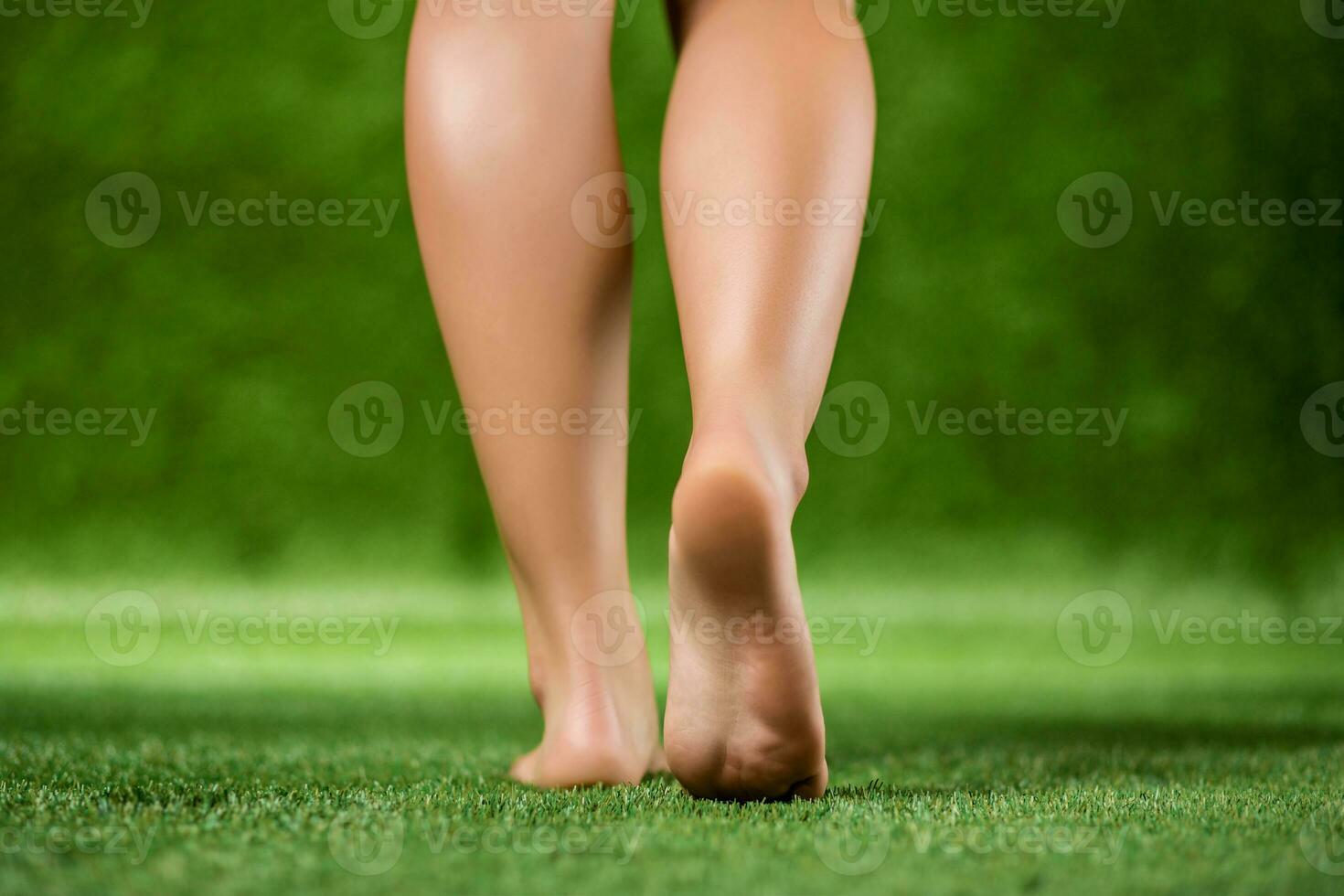 His bare feet beautiful woman close up are on a grass. photo