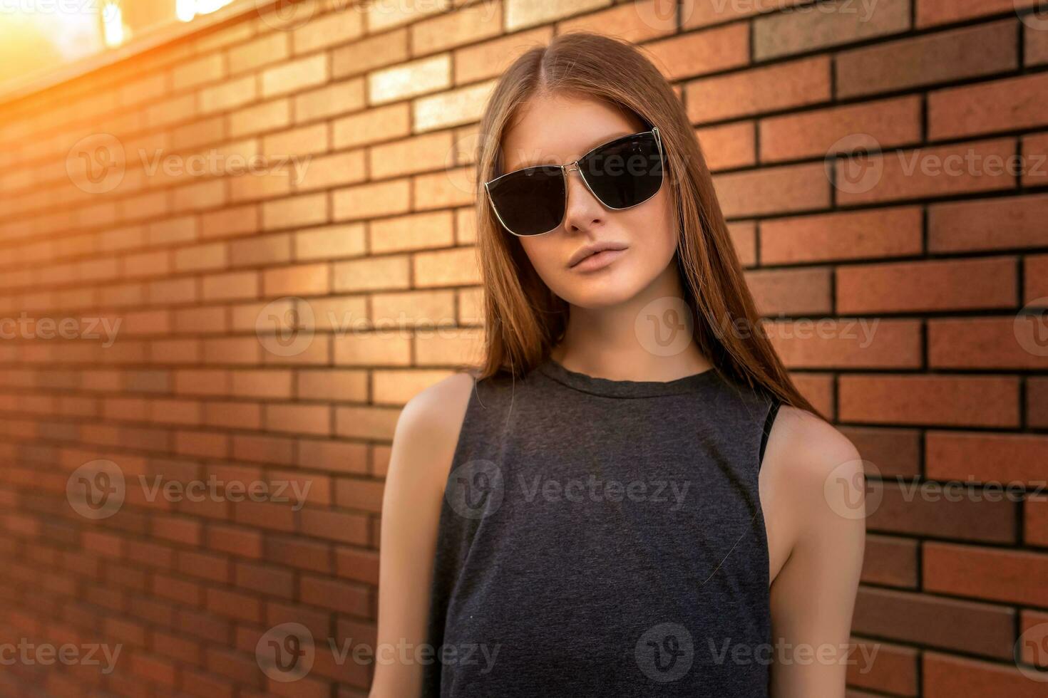 Portrait of Young Woman on Brick Wall Background. photo
