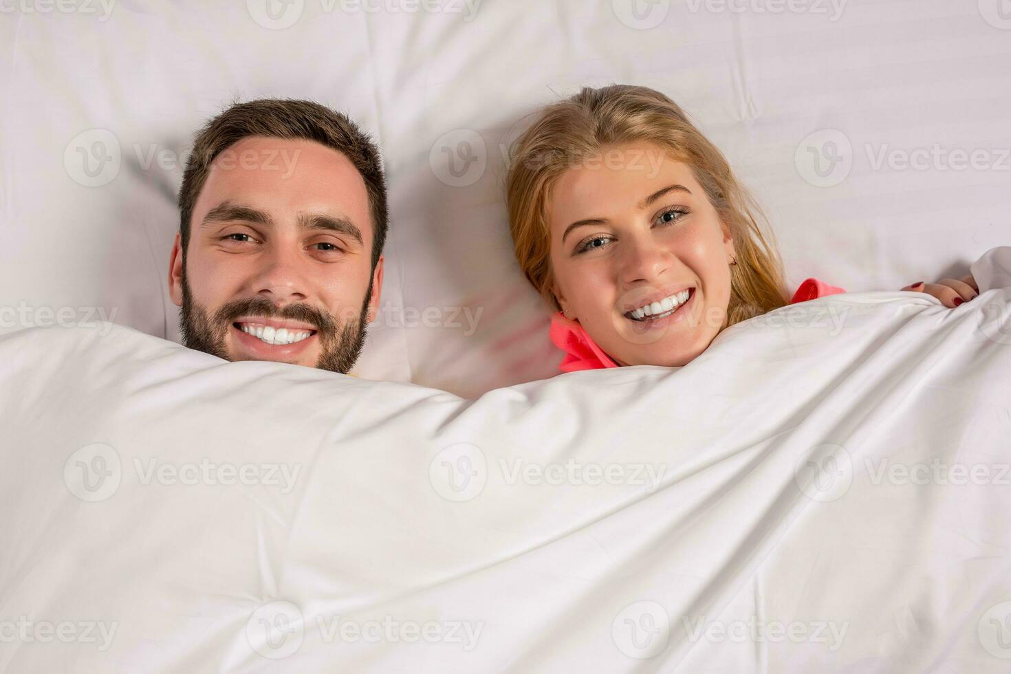 Young lovely couple lying and have fun in a bed photo