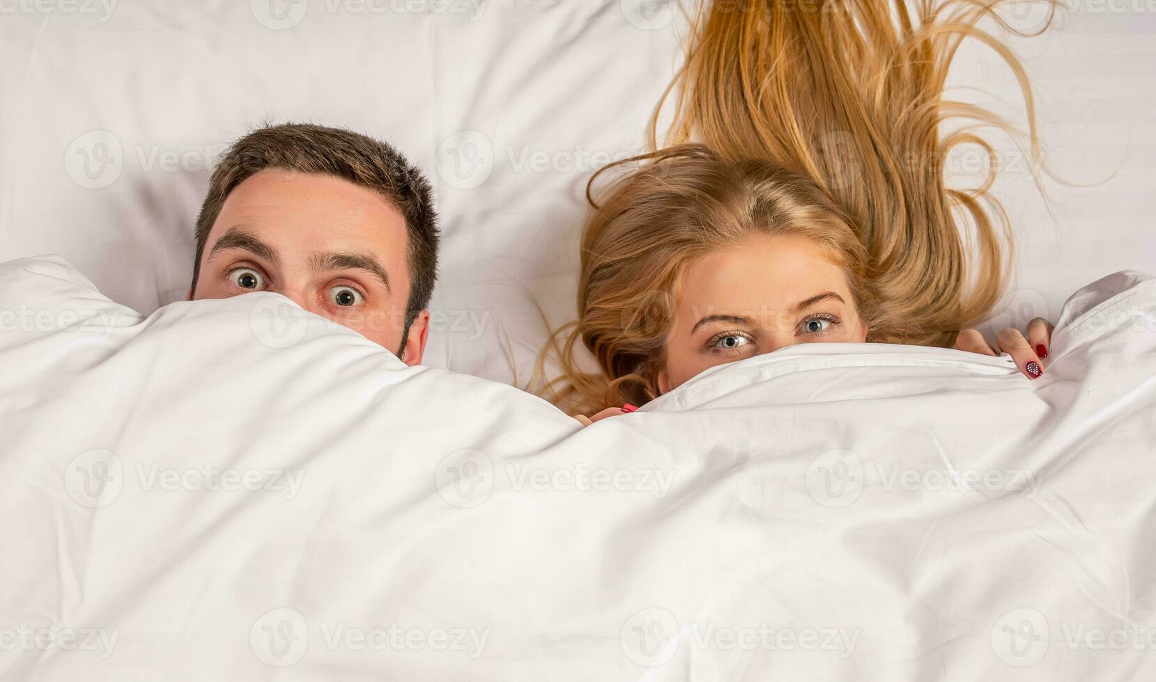 Young lovely couple lying and have fun in a bed photo