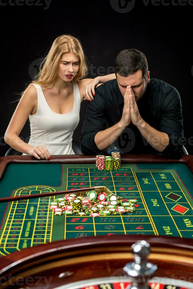 Men with women playing roulette at the casino. photo