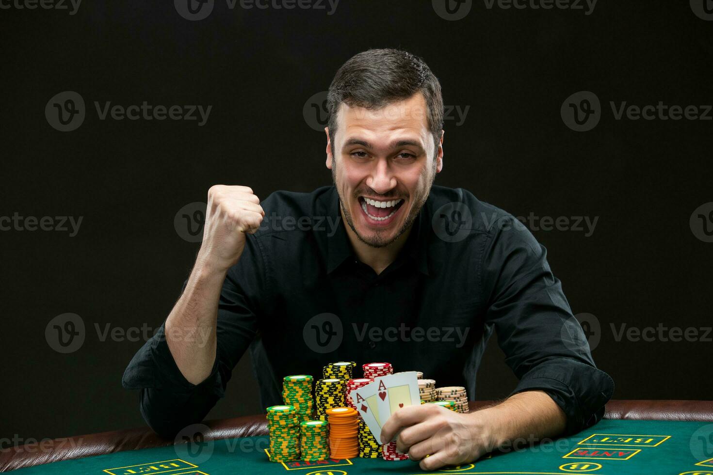Happy poker player winning and holding a pair of aces photo