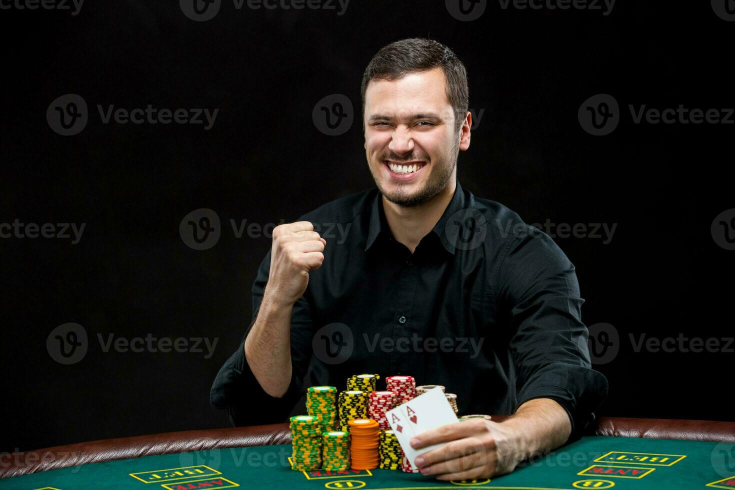 Happy poker player winning and holding a pair of aces photo