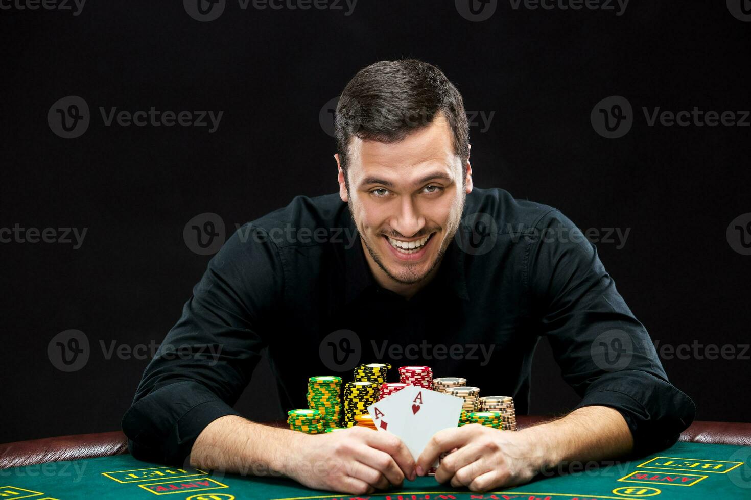 Happy poker player winning and holding a pair of aces photo