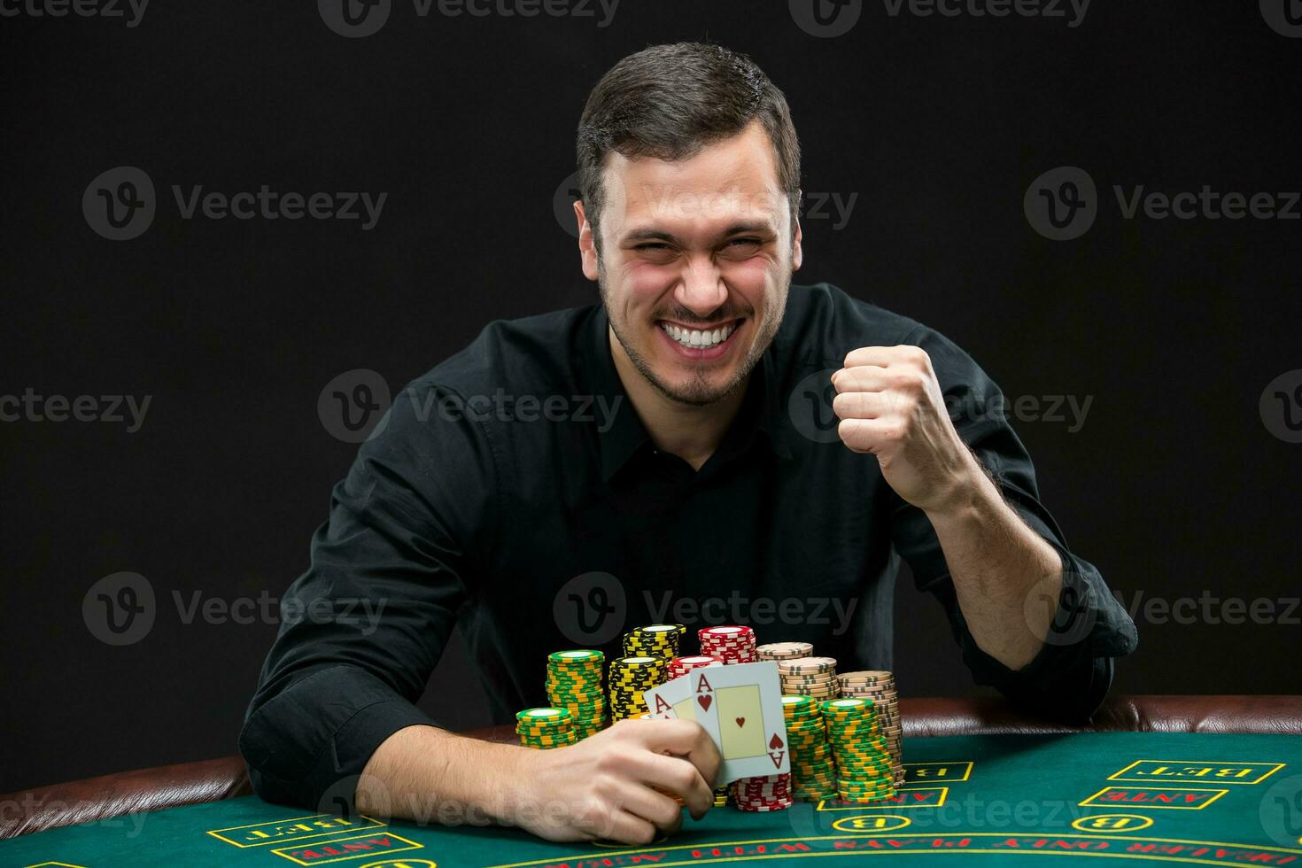 Happy poker player winning and holding a pair of aces photo