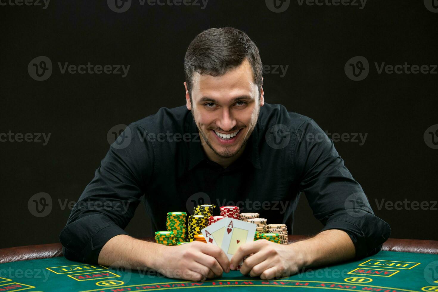 Happy poker player winning and holding a pair of aces photo