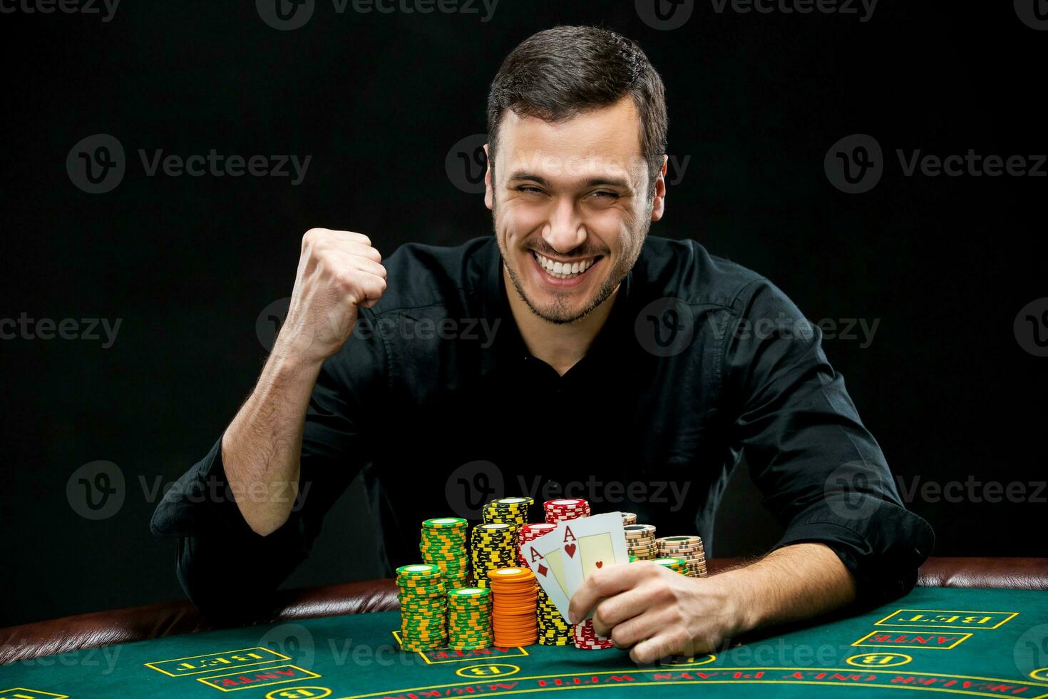 Happy poker player winning and holding a pair of aces photo
