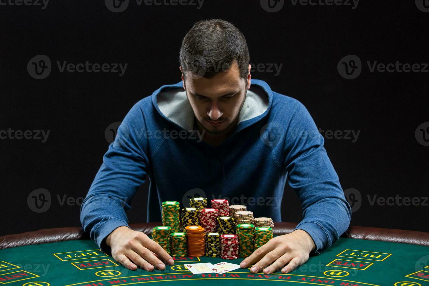 Portrait of a professional poker player sitting at pokers table photo