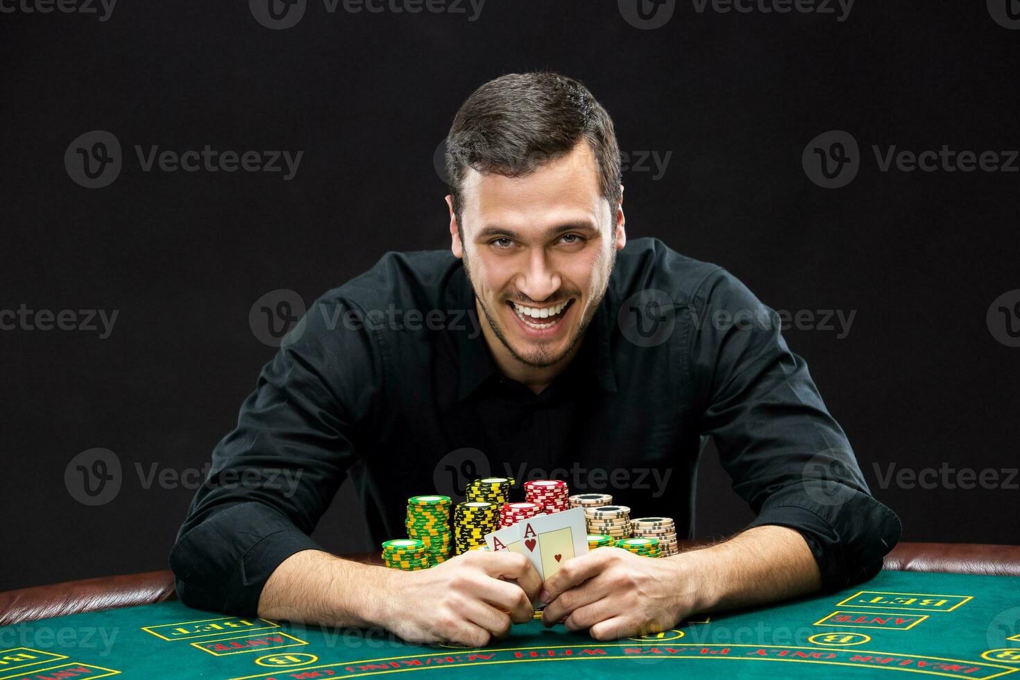 Happy poker player winning and holding a pair of aces photo