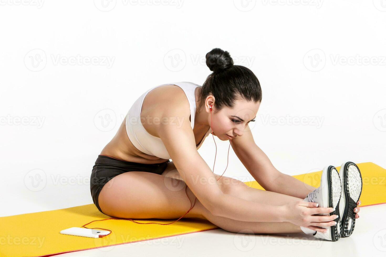 attractive woman doing exercises. Brunette fit body on yoga mat photo