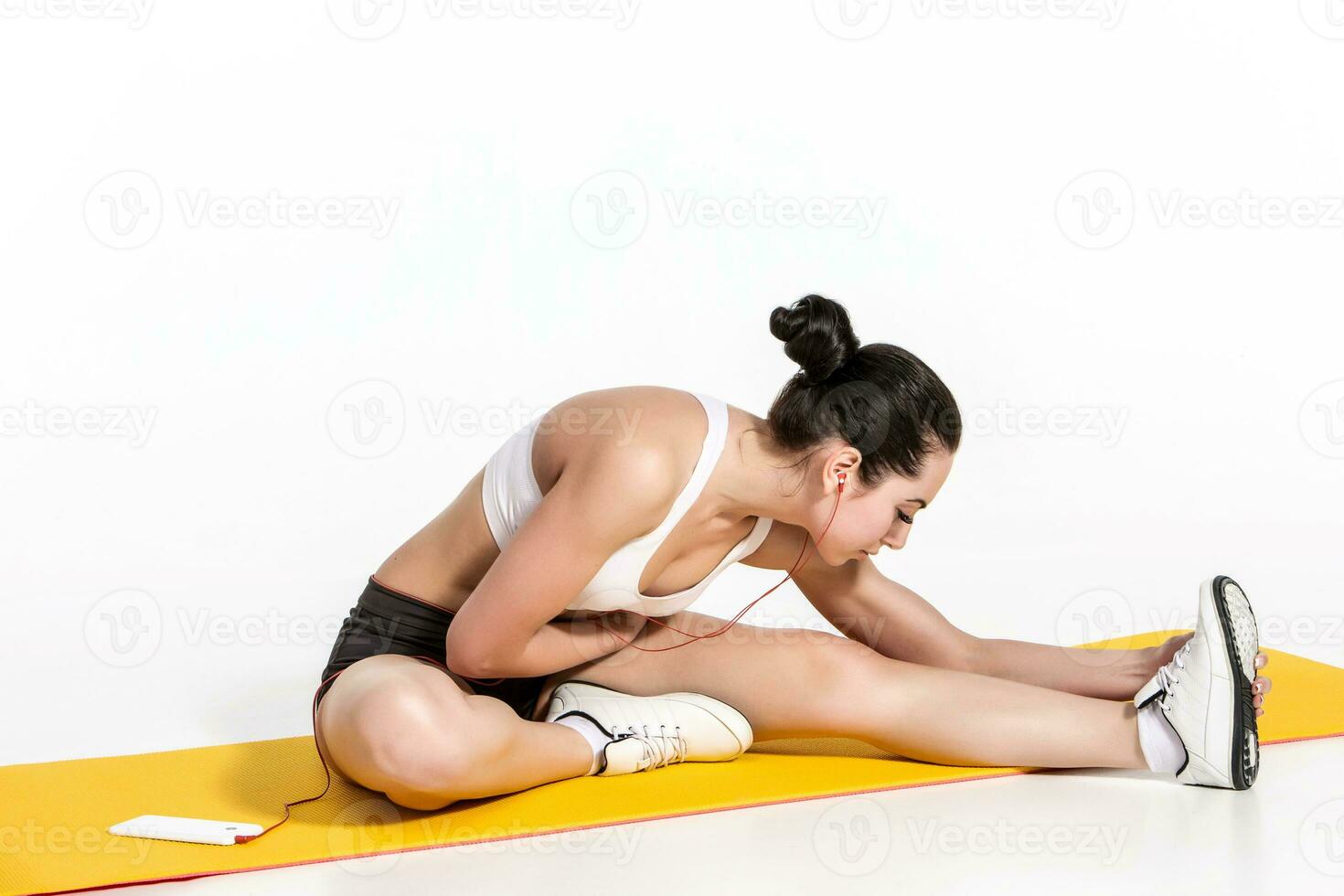 attractive woman doing exercises. Brunette fit body on yoga mat photo