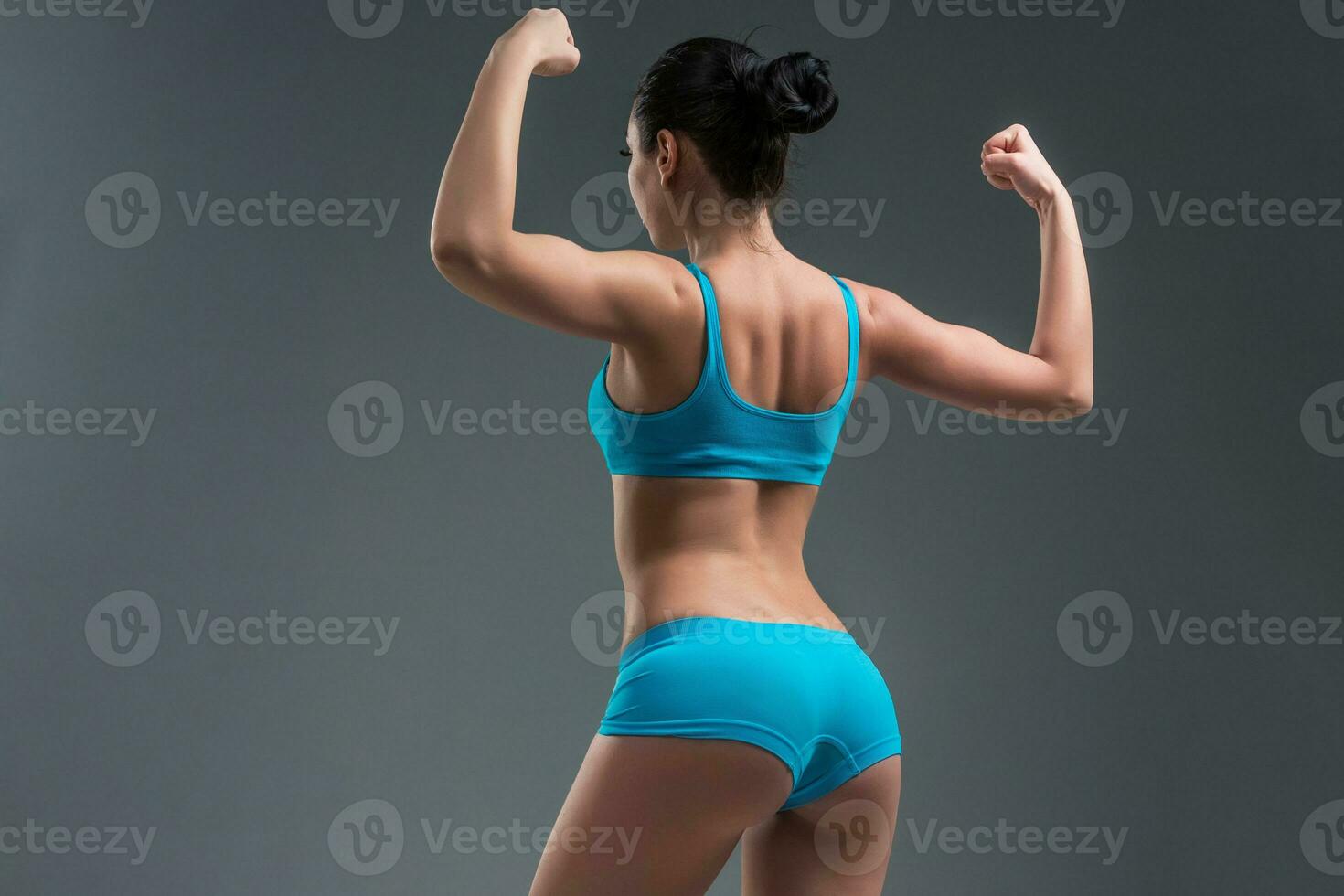 young athletic girl shows muscles photo