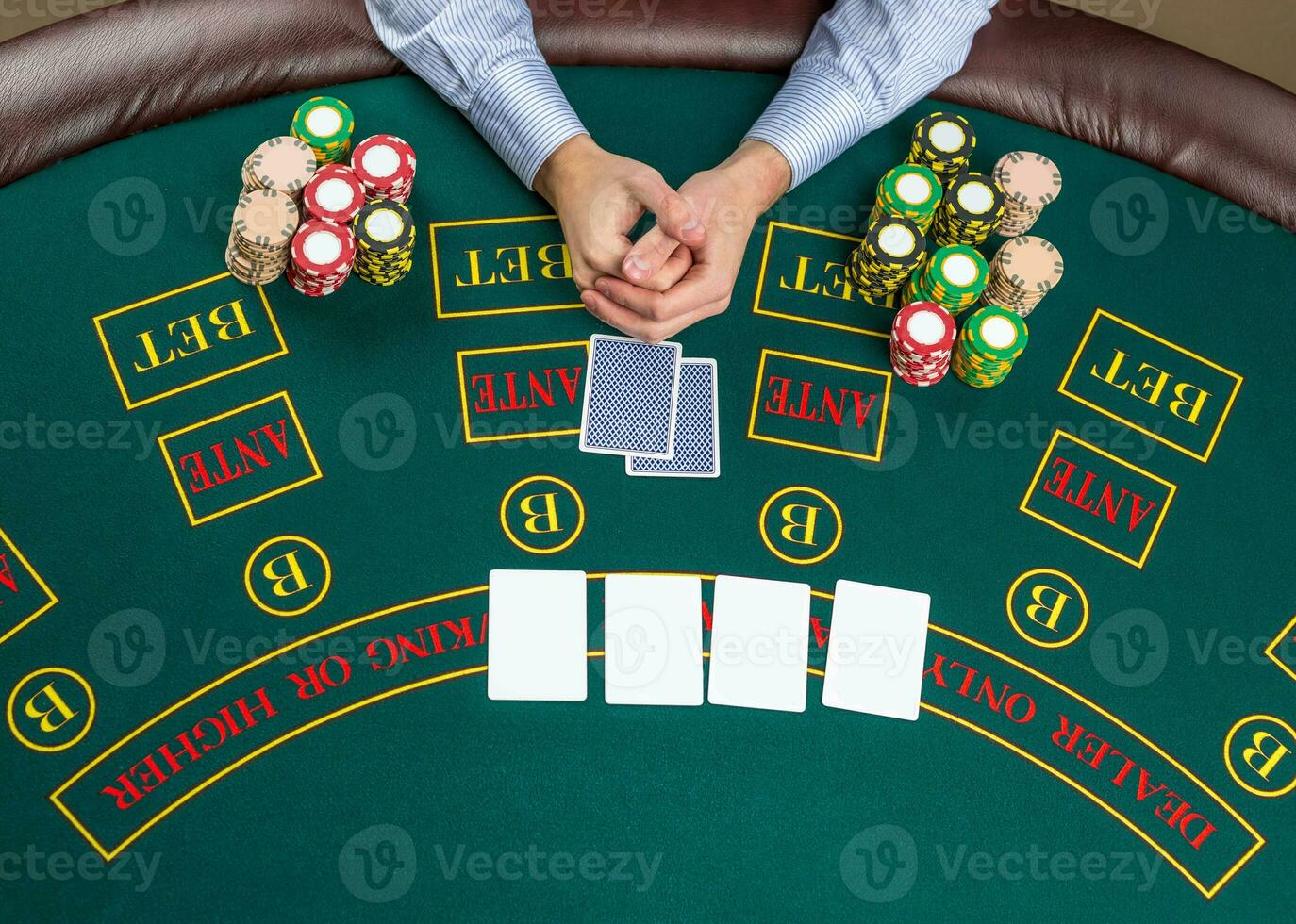 Closeup of poker player with playing cards and chips photo