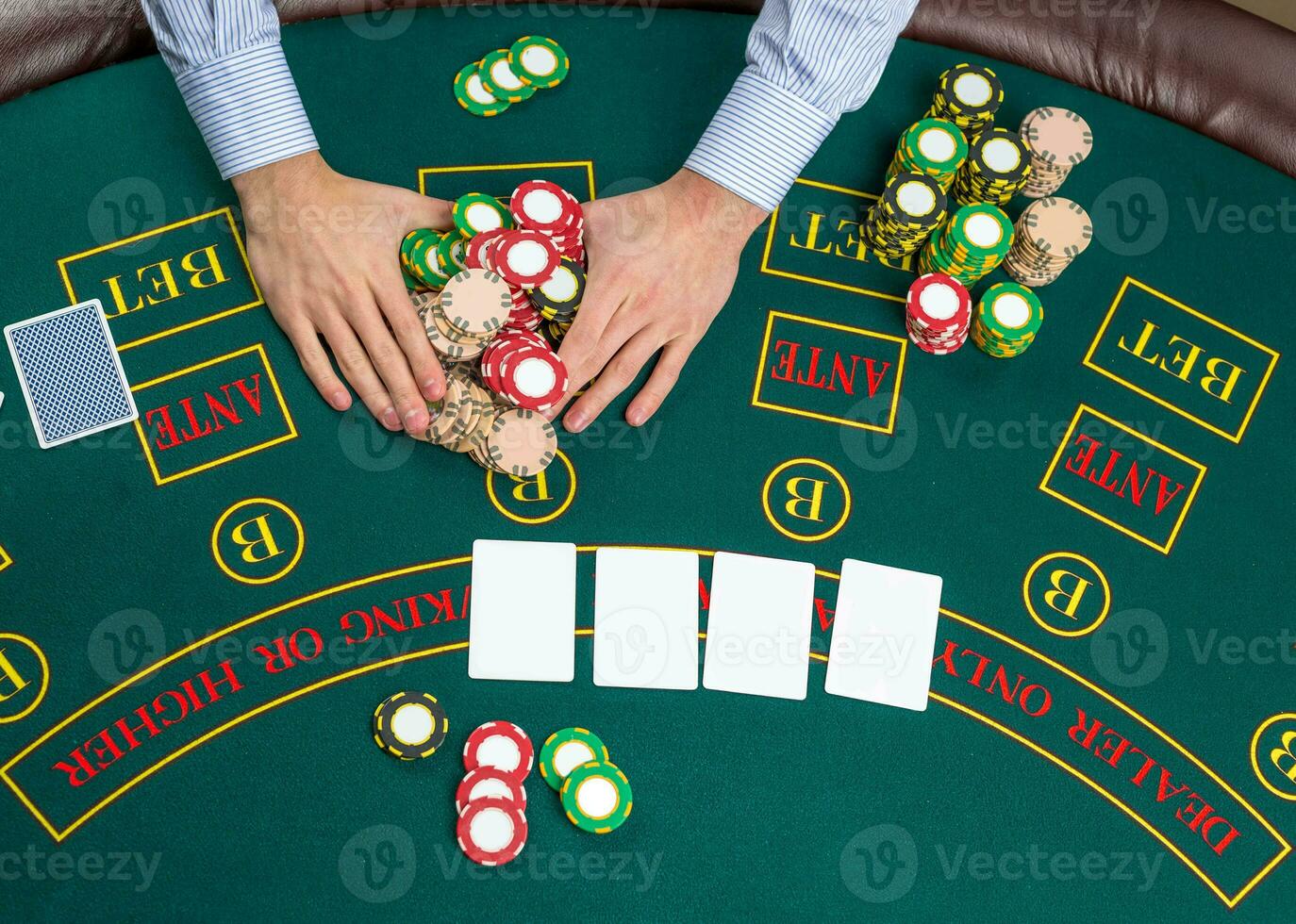 Closeup of poker player with playing cards and chips photo