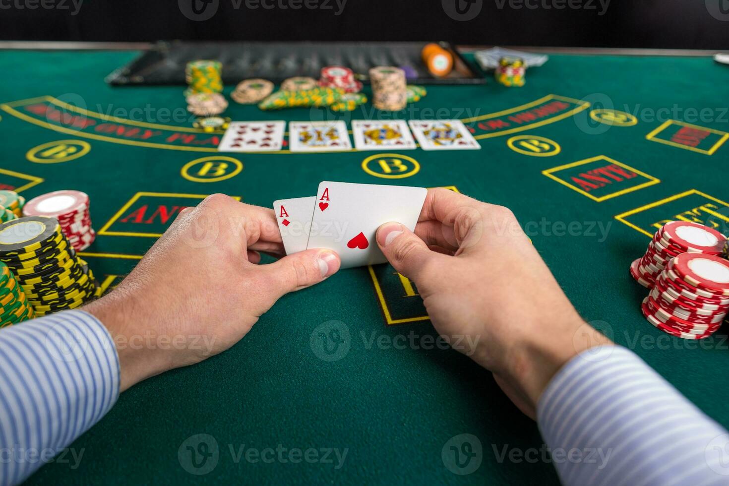 Male poker player lifting the corners of two cards aces photo