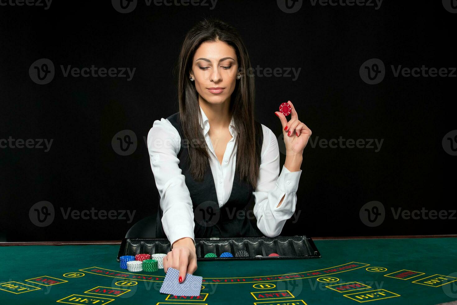 The beautiful girl, dealer, behind a table for poker photo