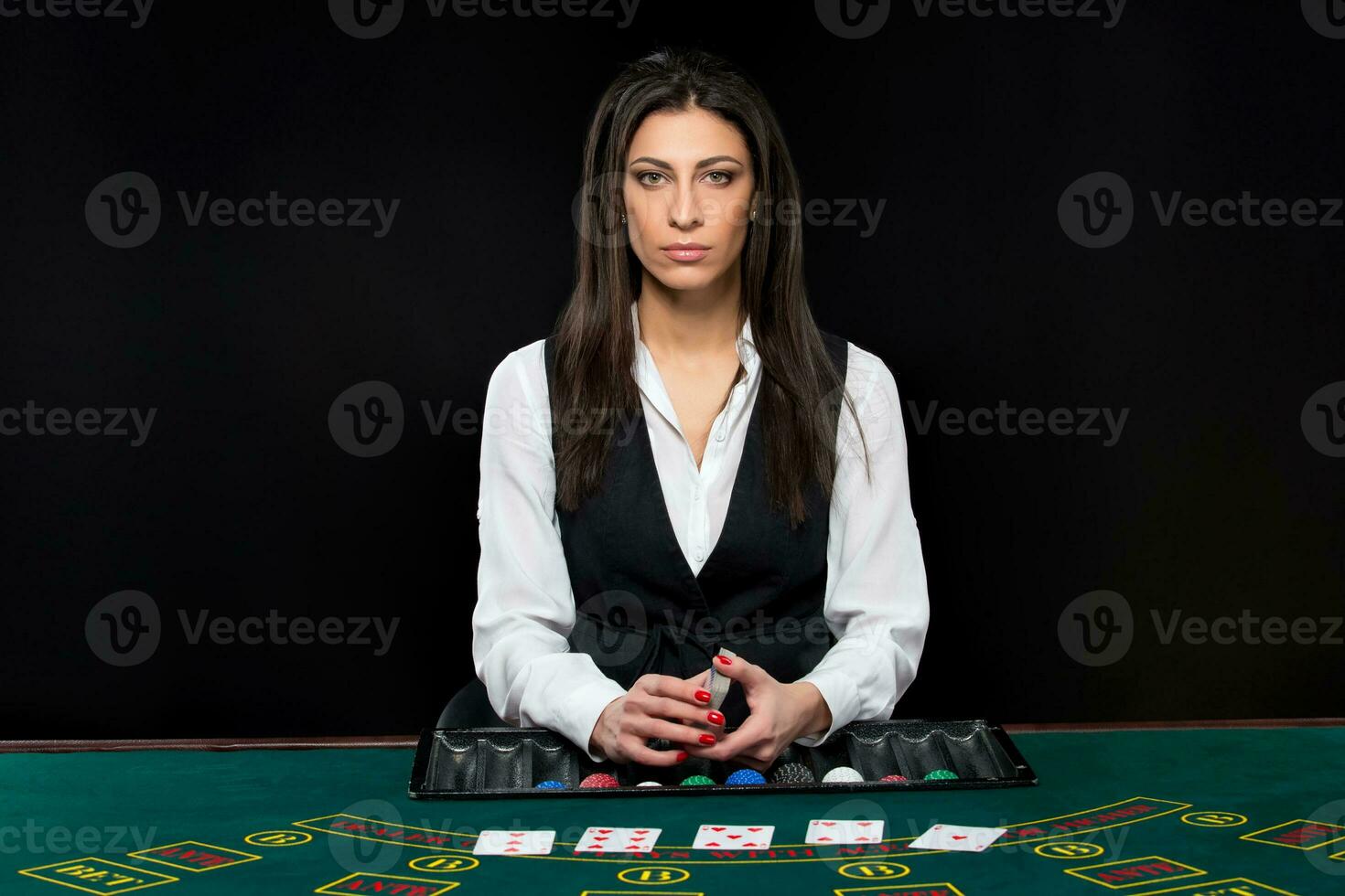 The beautiful girl, dealer, behind a table for poker photo