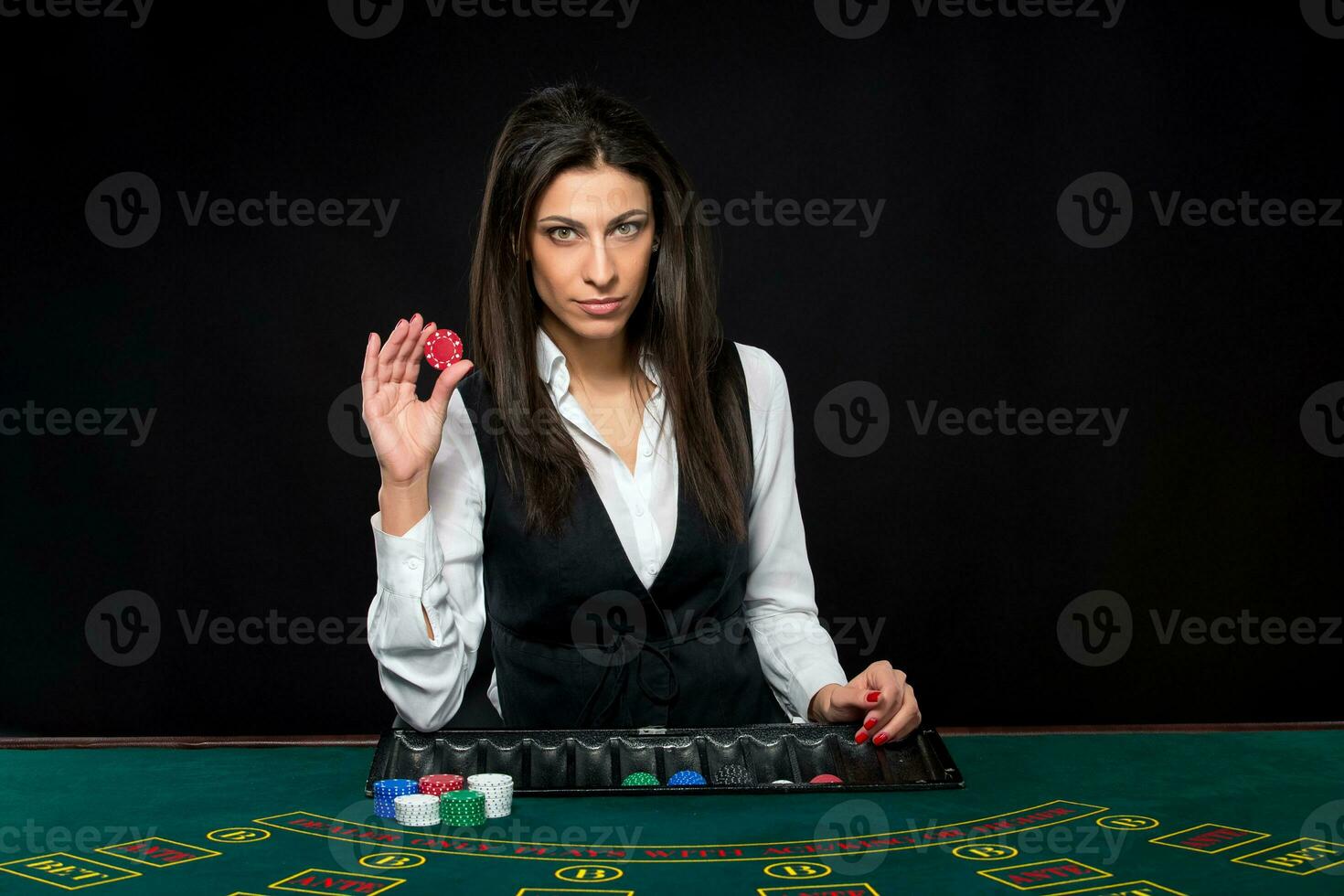 The beautiful girl, dealer, behind a table for poker photo