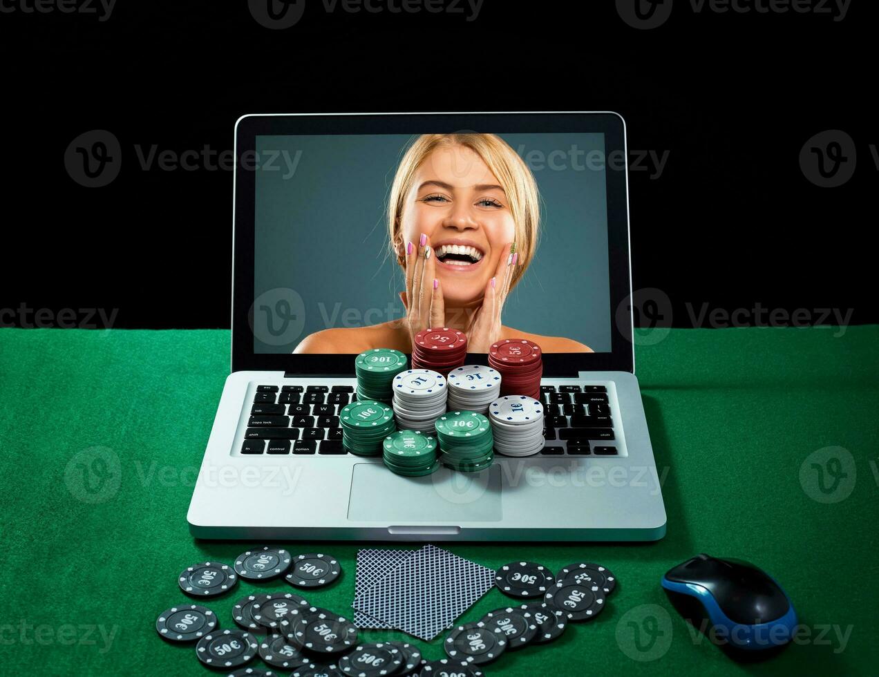 Casino chips and cards on keyboard notebook at green table. photo