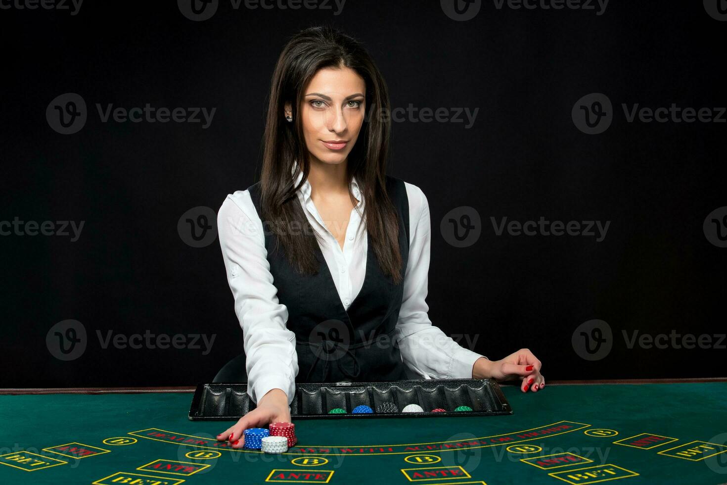 The beautiful girl, dealer, behind a table for poker photo