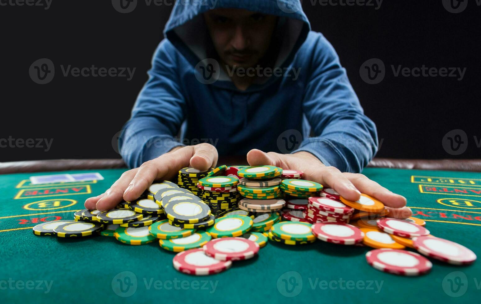 Poker player going all-in pushing his chips forward photo