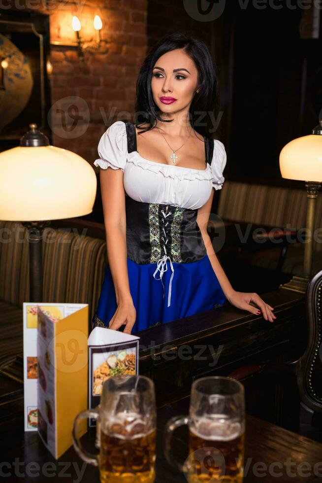 Young waitress brings beer to visitors photo