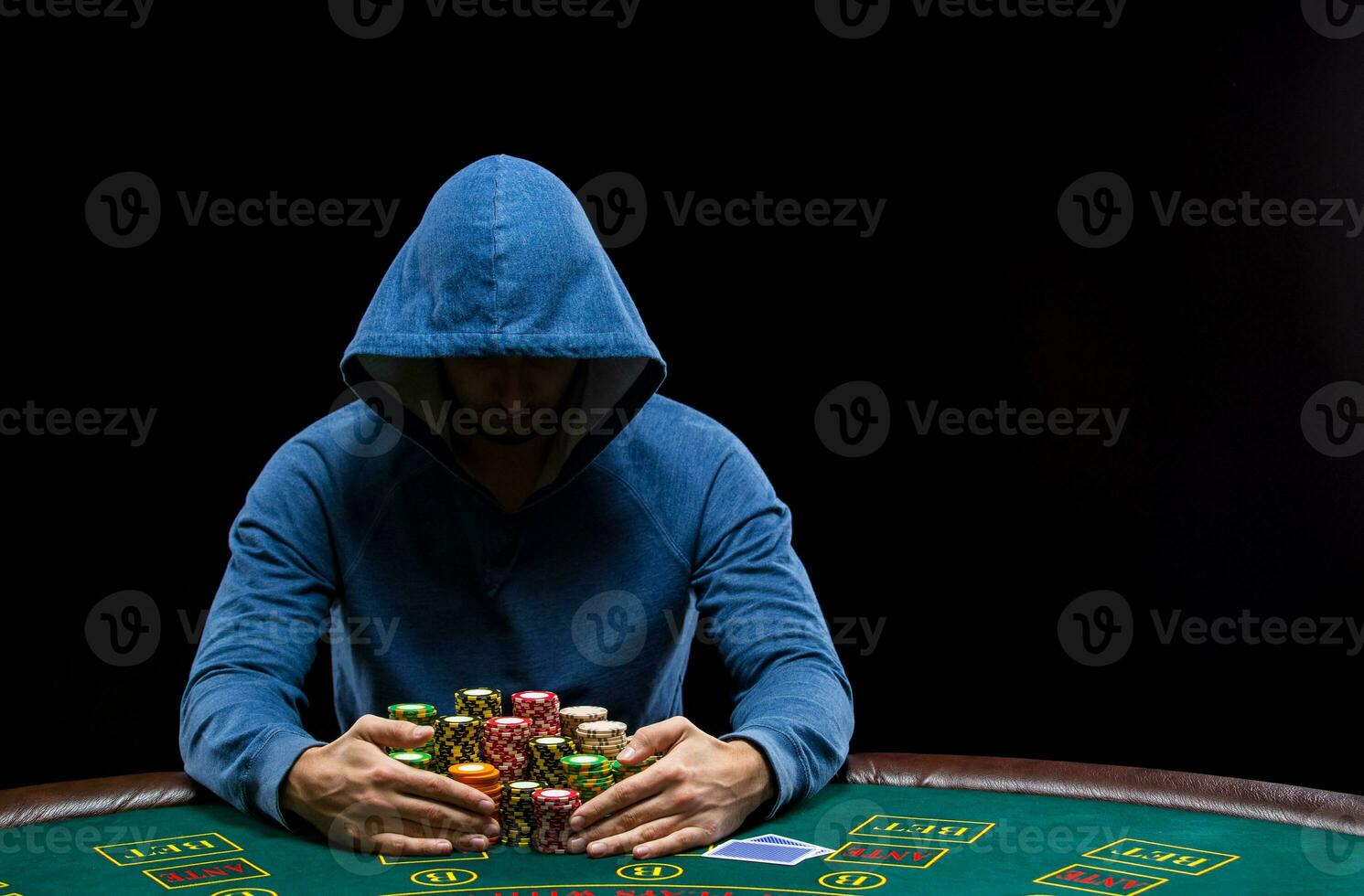 Poker player taking poker chips after winning photo