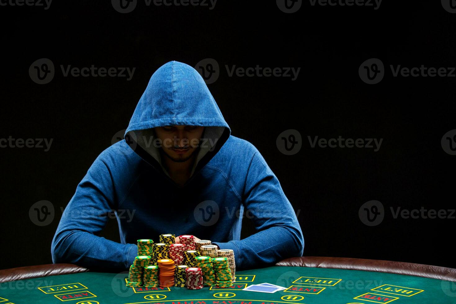 Poker player taking poker chips after winning photo