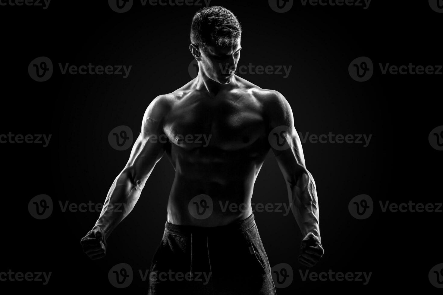 sexy muscular hombre posando con desnudo torso en negro antecedentes foto