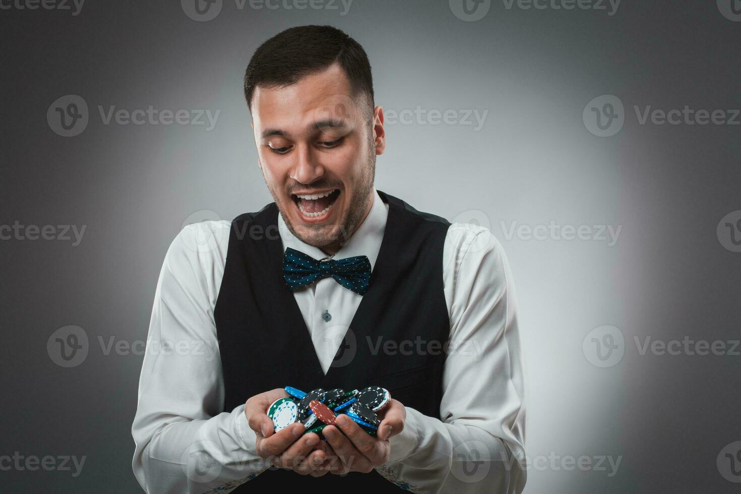 Poker player taking poker chips after winning photo