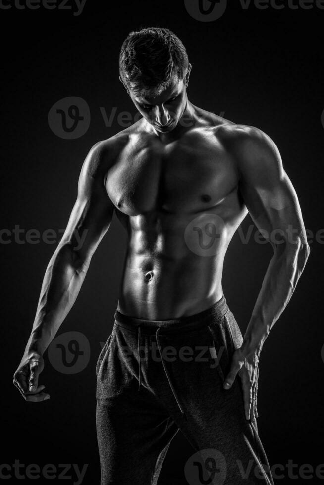 deportivo sano hombre posando y demostración su Perfecto cuerpo foto