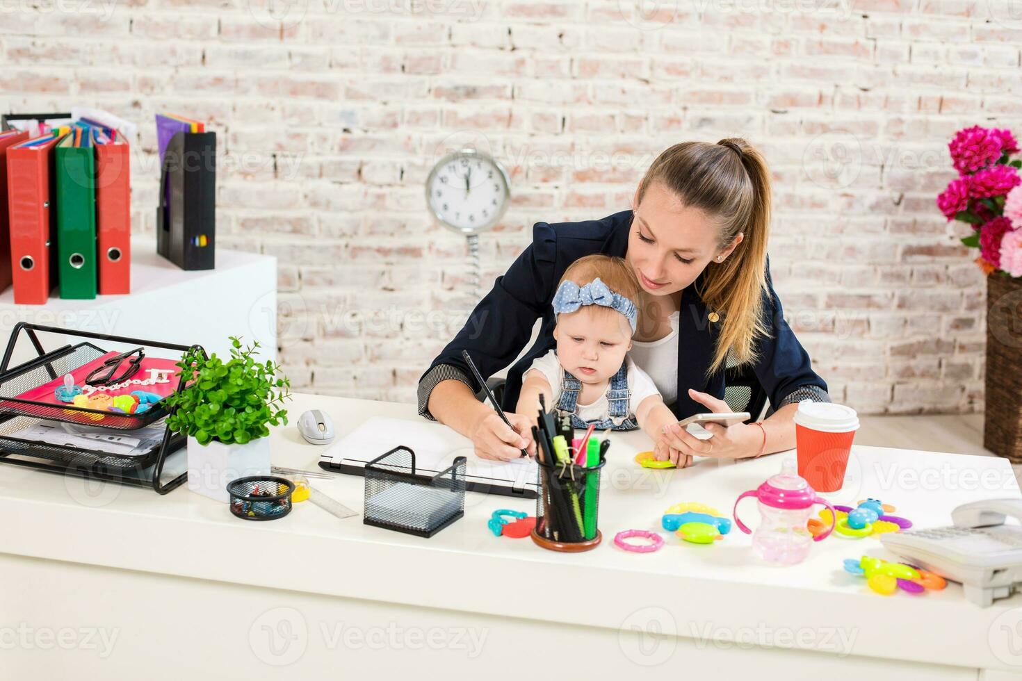 Mom and businesswoman working with laptop computer at home and playing with her baby girl. photo