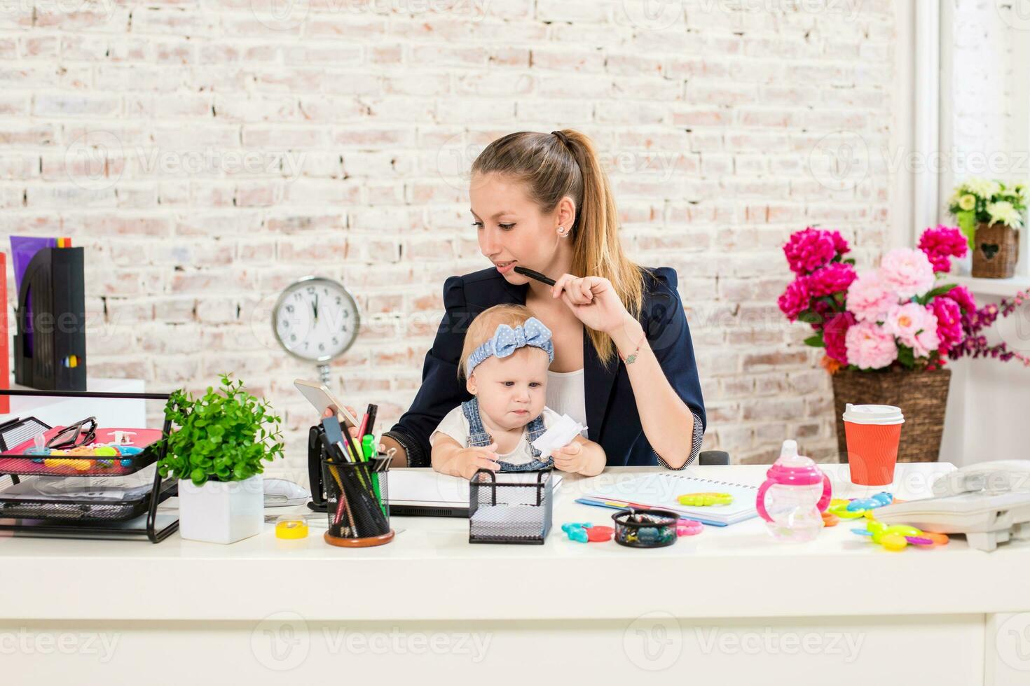 Mom and businesswoman working with laptop computer at home and playing with her baby girl. photo