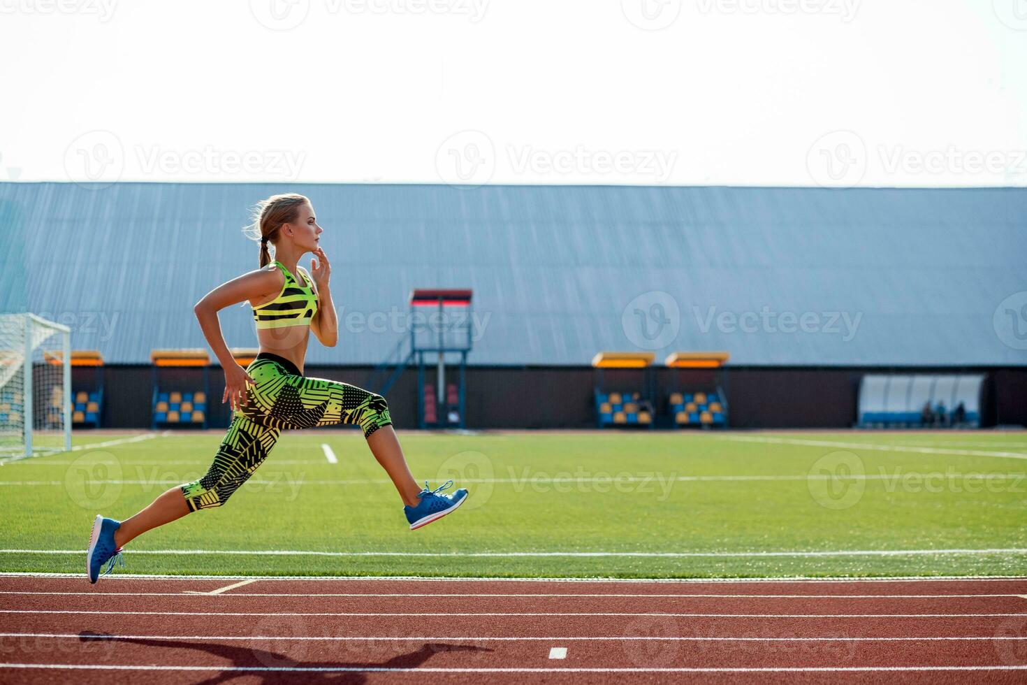 Beautiful young woman exercise jogging and running on athletic track on stadium. photo