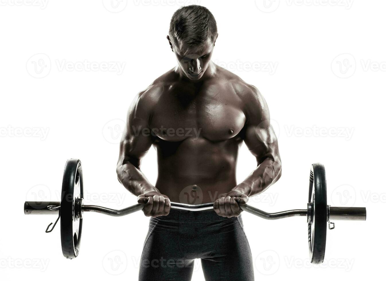 Young handsome man with naked torso and barbell photo