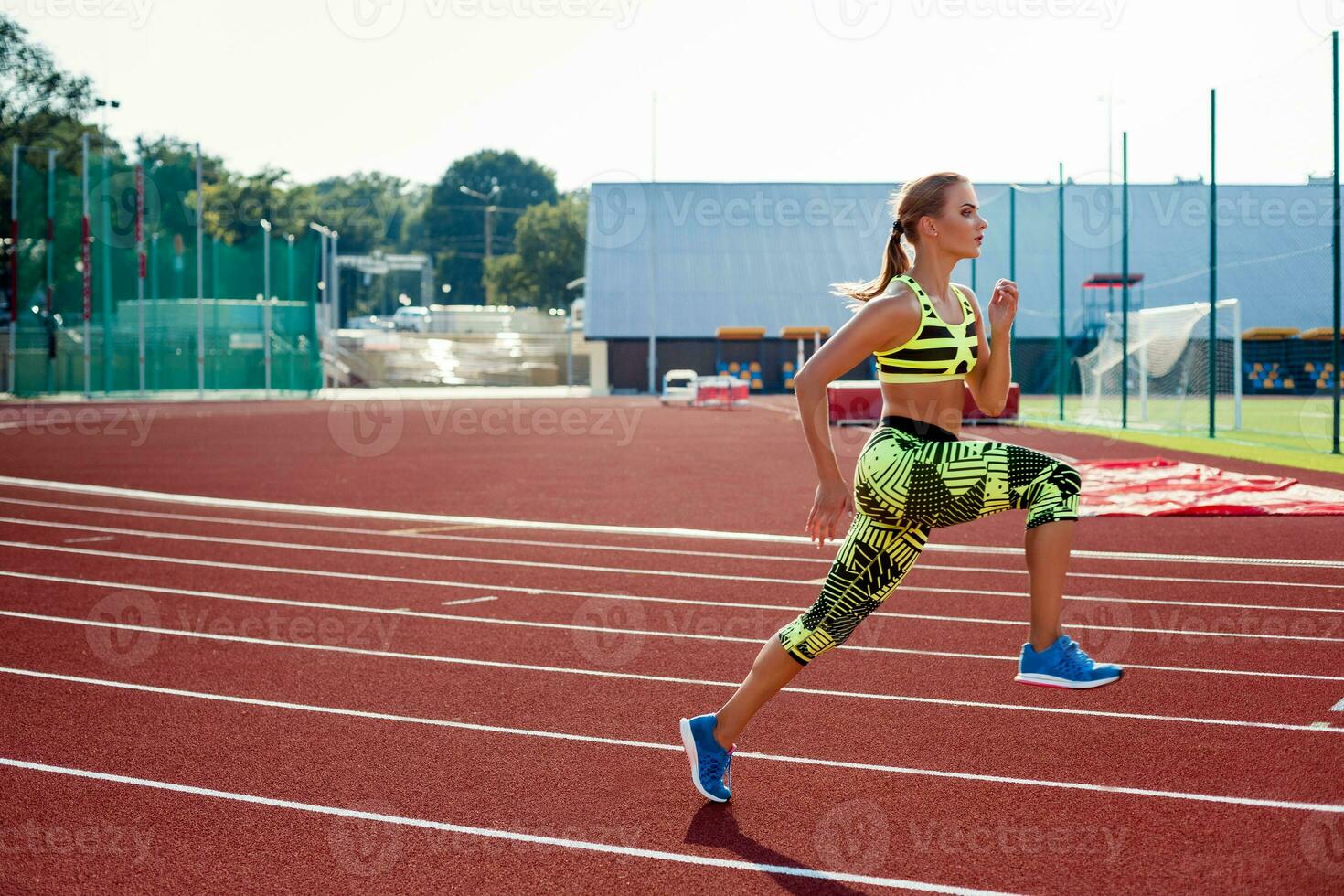 Beautiful young woman exercise jogging and running on athletic track on stadium. photo